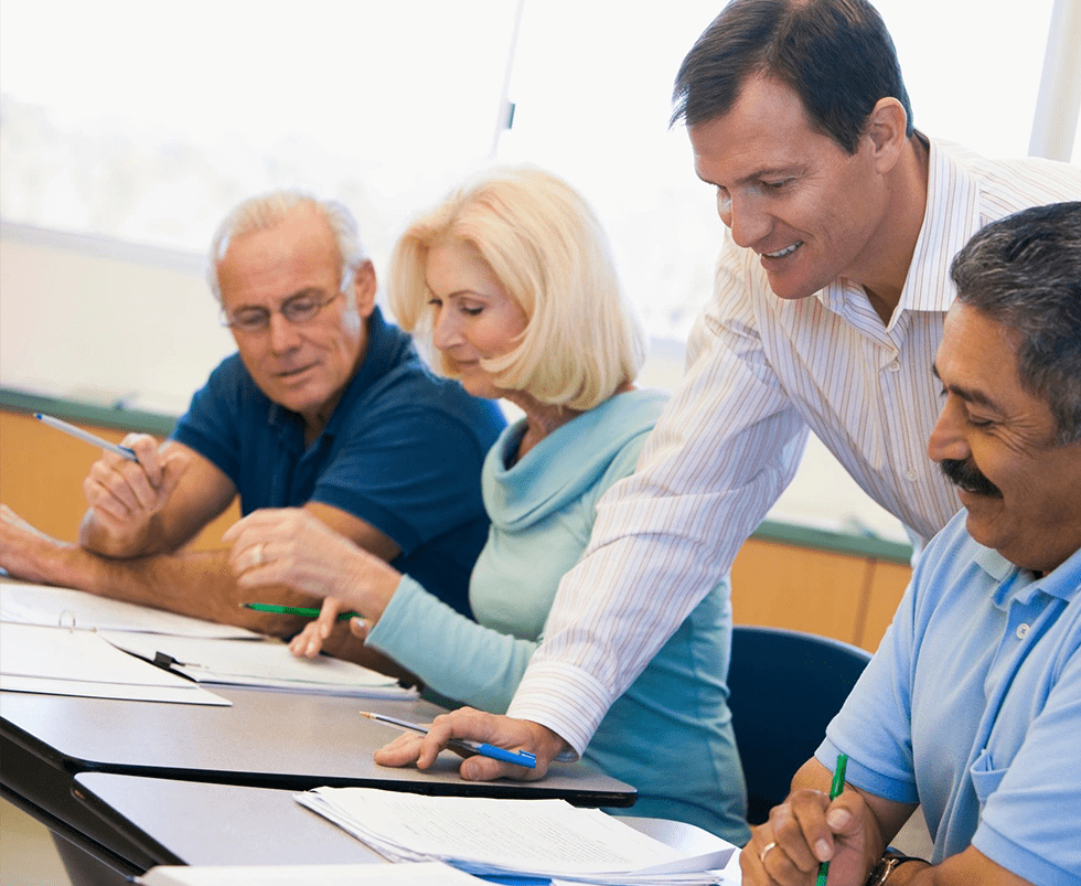 A group of people sitting at a table with papers.