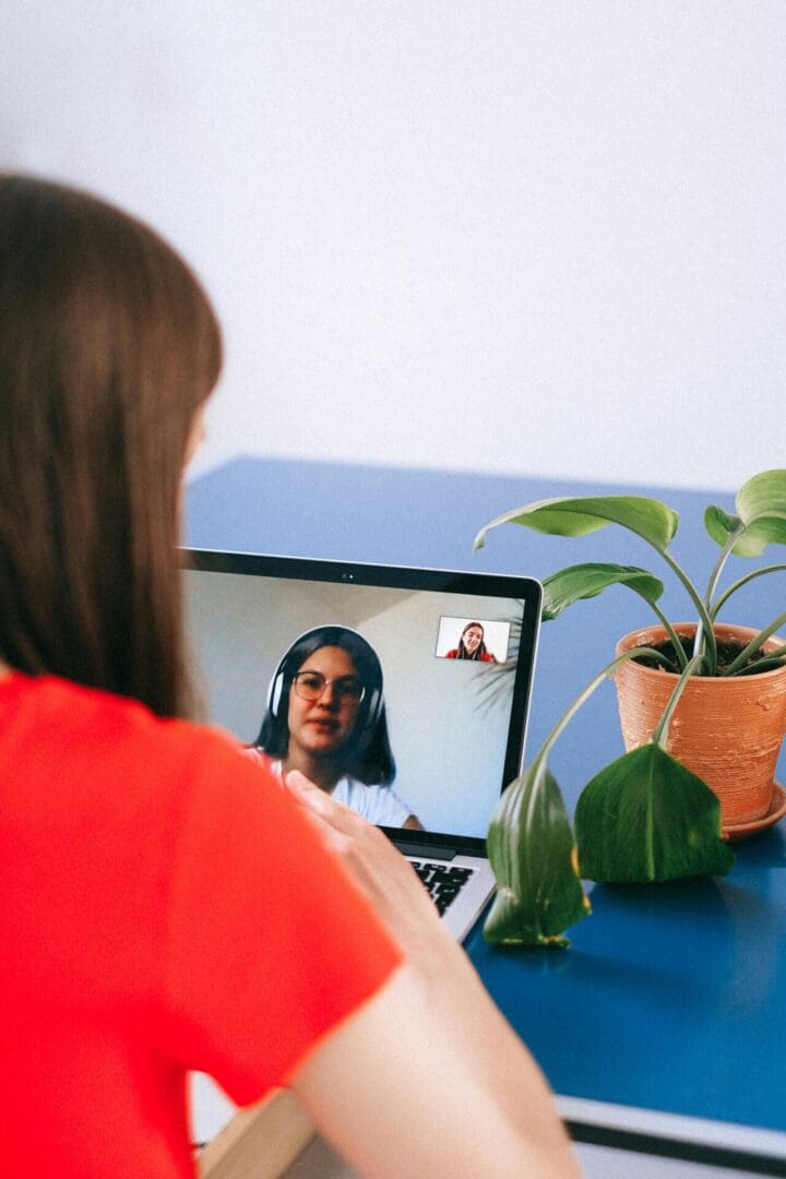 A woman sitting at a table with a laptop.