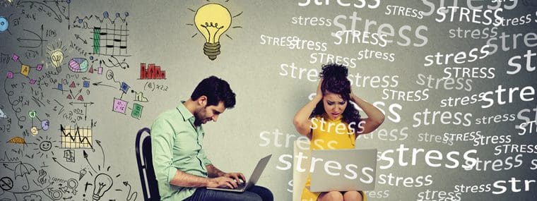 A man and woman sitting on the ground with laptops.