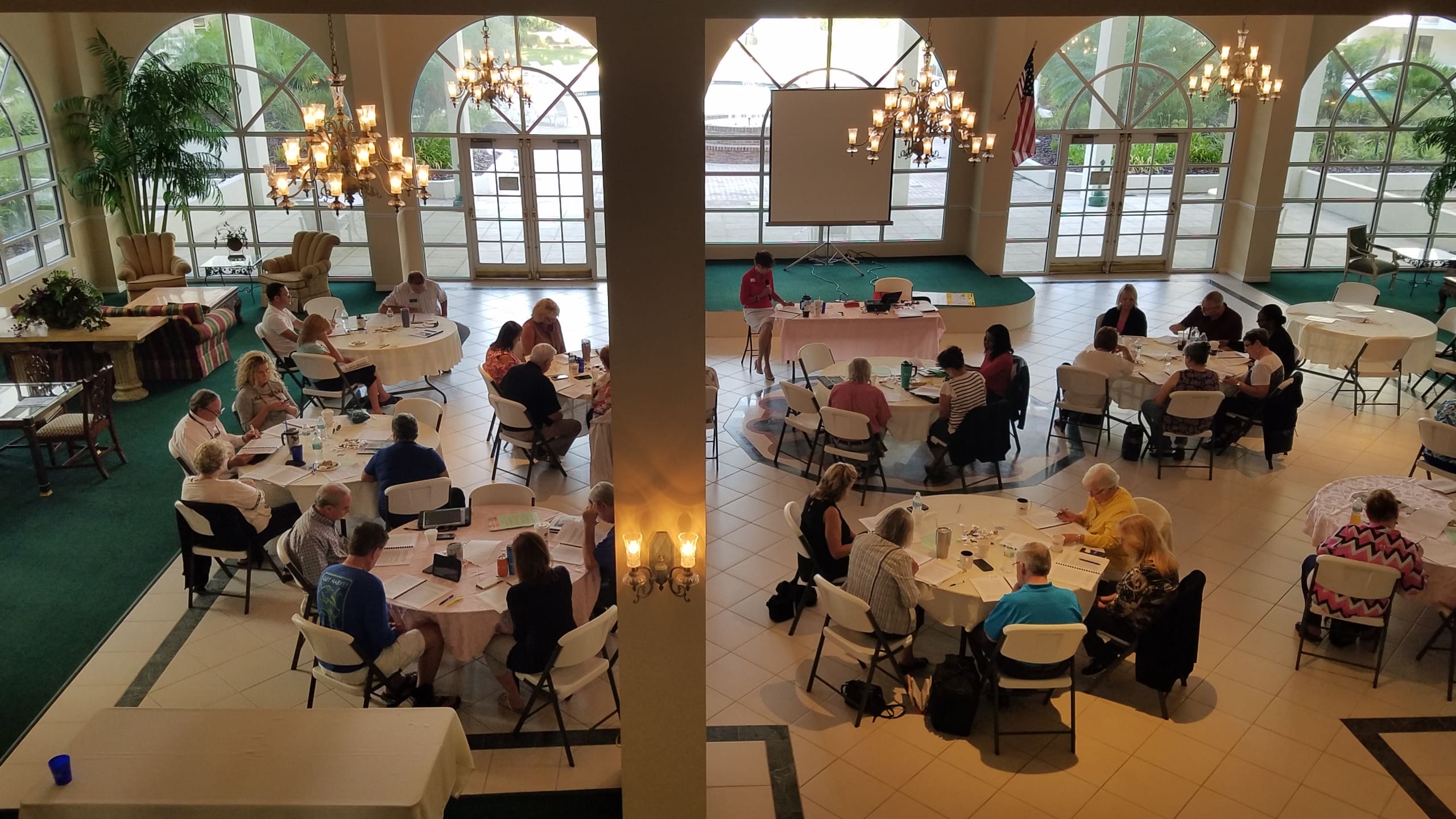 A group of people sitting at tables in an indoor setting.